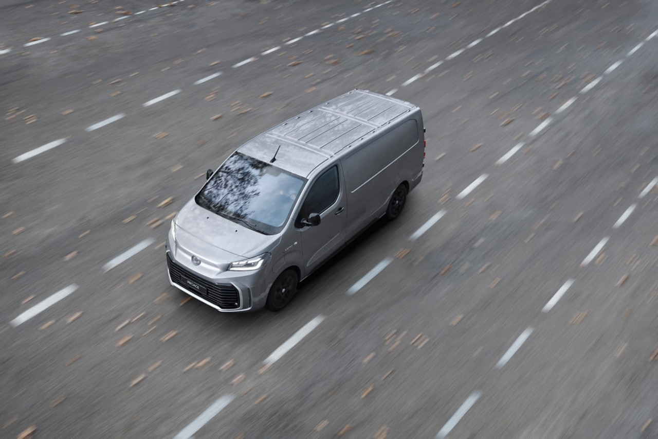 A Toyota Proace drives a long country road